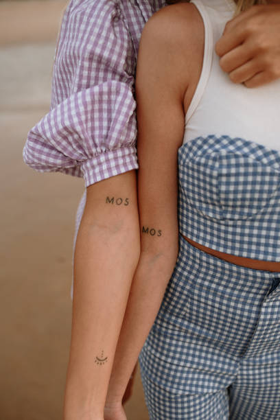 kahden ihmisen kädet joissa molemmilla tatuointina tekstit MOS.